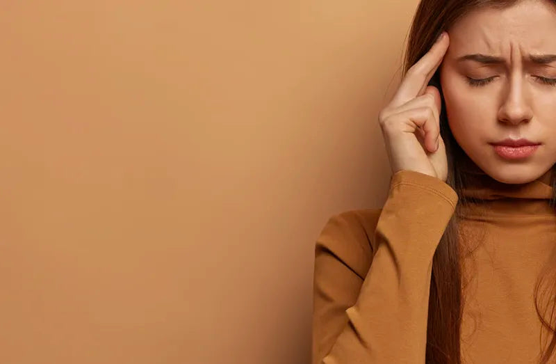 A woman holding her finger to her temple.
